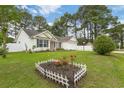 Attractive home with a well-kept lawn, garden beds, and a white picket fence at 5933 Rahnavard Blvd., Myrtle Beach, SC 29588