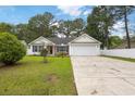 Cozy one-story home featuring a brick facade, white siding, and a well-manicured front yard at 5933 Rahnavard Blvd., Myrtle Beach, SC 29588