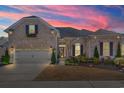 Brick home exterior at sunset, showcasing landscaping and a two-car garage at 860 Villarosa Dr., Myrtle Beach, SC 29572