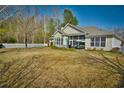 A spacious backyard with a lush green lawn, a white picket fence, and a screened-in porch, perfect for outdoor relaxation at 905 Adaline Ct., Myrtle Beach, SC 29579