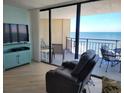 Living room with ocean view and balcony access at 1690 North Waccamaw Dr. # 807, Garden City Beach, SC 29576