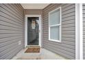 Front door entrance with glass panels and a welcome mat at 184 Retreat Pl., Little River, SC 29566