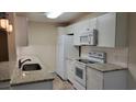 White kitchen with granite countertops and stainless steel appliances at 4309 Lotus Ct. # G, Murrells Inlet, SC 29576