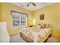 Bright bedroom features a queen-sized bed, plush bedding, neutral carpet, and large window for natural light at 4660 Lightkeepers Way # 37A, Little River, SC 29566
