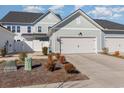 View of townhome's rear, showcasing garage and landscaping at 5353 Knobcone Loop # C-103, Myrtle Beach, SC 29577