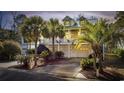 Two-story home with a two-car garage and palm trees in the evening at 65 Harbourreef Dr., Pawleys Island, SC 29585