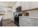 Modern kitchen with white cabinets, blue oven, and quartz countertops at 700 Choctaw Dr., Conway, SC 29526