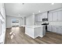 Modern kitchen featuring gray cabinets, quartz countertops, and island at 842 Cypress Preserve Circle, Longs, SC 29568