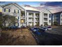 Exterior shot of the building, highlighting well-lit balconies and parking in front of this multi-story condo building at 901 West Port Dr. # 1706, North Myrtle Beach, SC 29582