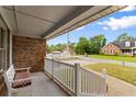 Inviting covered front porch with white railings offers a relaxing outdoor space to enjoy the neighborhood views at 1020 Thomas Ave., North Myrtle Beach, SC 29582