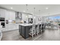 Spacious kitchen featuring white cabinets, stainless steel appliances, an island with seating, and hardwood floors at 1410 Saw Palmetto St., North Myrtle Beach, SC 29582