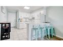 White kitchen with breakfast bar, teal stools, and modern appliances at 191 Maison Dr. # B206, Myrtle Beach, SC 29572