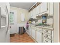 Bright kitchen with white cabinets and wood flooring at 2102 Calabash Circle, Little River, SC 29566