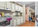 White kitchen cabinets, wood floors, and view into adjacent room at 2102 Calabash Circle, Little River, SC 29566