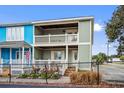 Two-story home with a gray and blue exterior, porch, and landscaping, behind a fence at 2102 S Ocean Blvd. # D, North Myrtle Beach, SC 29582