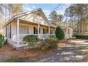 House exterior showcasing wrap-around porch and lush greenery at 4705 Harness Ln., Murrells Inlet, SC 29576