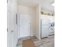 Bright entryway with wood-look floors, white door, and adjacent kitchen at 5751 Oyster Catcher Dr. # 931, North Myrtle Beach, SC 29582