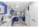 Modern kitchen with blue cabinets, white countertops, and stainless steel appliances at 6001-1027 S Kings Hwy., Myrtle Beach, SC 29575