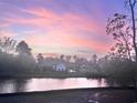 Scenic view of homes by a pond at dusk featuring the soft hues of the sunset reflected on the water at 7053 Byrnes Ln., Myrtle Beach, SC 29588