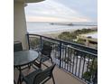 Oceanfront balcony with table and chairs, overlooking the beach and pier at 8560 Queensway Blvd. # 304, Myrtle Beach, SC 29572