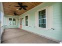 Front porch with white railings, ceiling fan, and light fixtures at 946 Crystal Water Way, Myrtle Beach, SC 29579