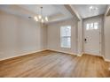 Bright dining room features a chandelier, wood-look flooring, and a white front door at 25 Northbrook Dr, Murrells Inlet, SC 29576