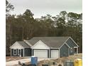 Charming single-story home with a three car garage, a concrete driveway, and blue siding with white accents at 25 Northbrook Dr, Murrells Inlet, SC 29576