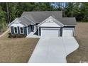 Aerial view of the home features two-car garage, blue siding, and long driveway at 25 Northbrook Dr, Murrells Inlet, SC 29576