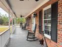 Relaxing front porch view featuring classic rocking chairs, brick accents, and ambient lighting at 305 W Raft St., Nichols, SC 29581