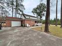 Exterior view of a brick home with an attached garage and rear porch, surrounded by trees at 305 W Raft St., Nichols, SC 29581