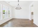 Open dining room featuring hardwood floors, large windows, and a modern chandelier at 35 Northbrook Dr, Murrells Inlet, SC 29576