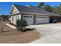 Two-car garage with white doors and a concrete driveway at 430 Long Lake Circle, Conway, SC 29527