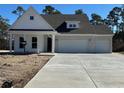 Charming one-story home featuring white siding and a three-car garage at 45 Northbrook Dr, Murrells Inlet, SC 29576