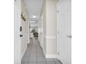 Neutral-toned hallway with tiled floors, coat rack, and white doors at 4846 Carnation Circle # 203, Myrtle Beach, SC 29577