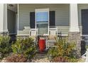 Inviting front porch featuring rocking chairs, a 'Welcome' sign, and stone accents at 901 Queensferry Ct., Conway, SC 29526