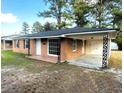 Brick exterior elevation with awning and carport showing off beautiful landscaping and architectural details at 109 S Maple Ave., Andrews, SC 29510