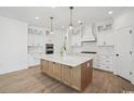 Modern kitchen island with white countertop and wooden base, complemented by white cabinets and stainless steel appliances at 1816 Tryon Dr, Myrtle Beach, SC 29588