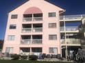 Rear view of a three-story building with multiple balconies at 2710 Ocean Blvd. S # 406, Myrtle Beach, SC 29577
