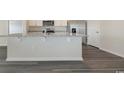 A kitchen island with light countertops and white cabinets overlooks the living area at 6044 Fuller Ridge Ct, Conway, SC 29526
