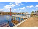 Waterfront dock with weathered wood and a boat lift on a sunny day with blue skies and cloud accents at 626 Lorenzo Dr. # 626, North Myrtle Beach, SC 29582