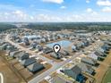 Overhead view of a neighborhood featuring single-Gathering homes, a central lake, and well-maintained landscaping at 775 Oyster Bluff Dr., Myrtle Beach, SC 29588