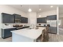 Modern kitchen with dark cabinets, white countertops, and stainless steel appliances at 1110 Barrington Way, Conway, SC 29526