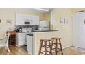 Well-equipped kitchen with white cabinetry, a breakfast bar, and modern appliances at 1356 Glenns Bay Rd. # E 204, Surfside Beach, SC 29575