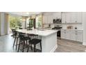Open kitchen with an eat-in island, stainless steel appliances, and a view to the dining area with sliding glass doors at 394 Glacier Way, Conway, SC 29526