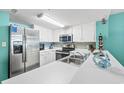 White cabinets, stainless steel appliances, and teal backsplash at 501 S Ocean Blvd. # 505, North Myrtle Beach, SC 29582
