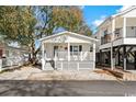 White cottage with a front porch, and nicely landscaped yard at 6001-1235 S Kings Highway, Myrtle Beach, SC 29575