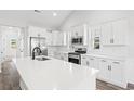 White kitchen with an island, stainless steel appliances, and quartz countertops at 1113 Crooked Hook Rd., North Myrtle Beach, SC 29582