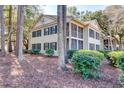 Exterior of a 2-story home with dual screened-in porches, surrounded by trees at 14 Stillwood Dr. # 2, Pawleys Island, SC 29585