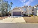 Two-story house with beige siding, two-car garage, and manicured lawn at 220 Machrie Loop # A, Myrtle Beach, SC 29588