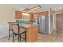 Small kitchen with wood cabinets, a breakfast bar and stainless steel appliances at 3700 Golf Colony Lane # 20-L, Little River, SC 29566